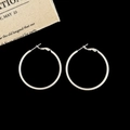 Classic silver hoop earrings displayed on a dark background with vintage fabric detail - Silver 4cm Hoop Earrings