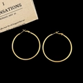 Detailed close-up of large golden hoop earrings on a black background for a luxury look - Gold 5cm Hoop