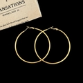 Detail of large 18K gold hoop earrings with polished mirror finish on black background - Gold 6cm Hoop