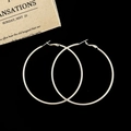 Macro view of large polished silver hoop earrings on a black background with fabric - Silver 7cm Hoop