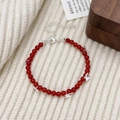Detalle de pulsera de ágata roja con dijes de mariposa plateados y cierre de langosta - Pulsera de Ágata Roja