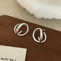 Dettaglio di orecchini geometrici a cerchio in argento con design a strati moderni - Argento
