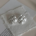 Detailansicht silberner quadratischer Ohrstecker mit Flechtstruktur auf handgeschöpftem Papier - Silber