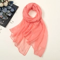 Detail of coral pink chiffon scarf with neat hemmed edges and soft translucent texture - Light Coral