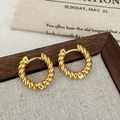 Close-up of golden twisted hoop earrings on fabric background with vintage aesthetic - Gold Twist Stud Earrings / Gold