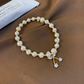 Detailed shot of pearl bracelet with golden cherry pendant and sparkling rhinestones - Cherry Style