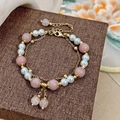 Double-layer gold chain bracelet featuring pink natural stones and white pearls on display - Pink Natural Stone Bracelet