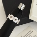 Primer plano de anillo vintage de flores con gemas púrpuras y textura plateada - Plateado