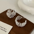 Detailopname van zilveren holle kettingschakel oorbellen op een houten displayblok - Zilver