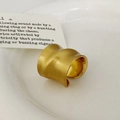 Close-up of golden wide brushed open ring with irregular wavy minimalist design - Gold Brushed Ring