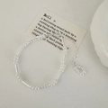 Dettaglio ravvicinato di un bracciale con perle argentate in stile minimalista francese - Bracciale / Argento
