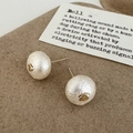 Detailed macro view of cotton pearl earrings with golden accents on a vintage background - Small Round Cotton Pearl Stud Earrings