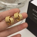 Macro shot of large twisted gold ribbon earrings with a high-polished metallic finish - Twisted Ribbon Shell Pattern Style (A-883)