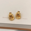 Detailed macro shot of gold-plated multi-layered intertwining hoop earrings on white card - Multi-circle Interleaved Vintage Style (A-282)