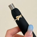 Close-up of bowknot ring with micro-set zircons and a delicate pearl band finish - Golden Bow Pearl Ring / Gold