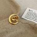 Dettaglio di un ear cuff a doppio cerchio dorato lucido su sfondo minimalista - Oro