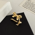 Detalle de un ear cuff de lazo dorado con circón sobre un soporte de exhibición negro - Ear Cuff de Lazo Dorado