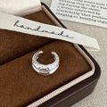 Dettaglio macro di earcuff in argento martellato su scatola di velluto marrone - Argento