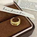 Primo piano di un ear cuff dorato martellato con texture in una scatola regalo in velluto - Oro