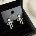 Détail de boucles d'oreilles nœud avec perles présentées sur un écrin en velours noir - Style Nœud Perle de Coquille Argent