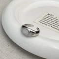 Vista dettagliata di un anello a sigillo ovale con finitura argento lucido su un vassoio ceramica - Occhio di Gatto Bianco Argentato (C-392银色)