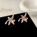 Close-up of pink enamel flower earrings on a black mirror with elegant reflections - Orange Enamel Flower Stud Earrings