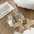 Detail of silver drop earrings with lava texture and dangling white shell discs - Silver