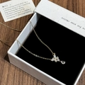 Dettaglio della collana a farfalla dorata con zirconi in una elegante scatola per gioielli - Collana a farfalla in zircone a goccia d'acqua d'oro