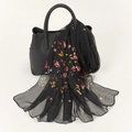 Elegant black georgette floral scarf with red and yellow patterns draped on a handbag - 160x50cm / Black Floral