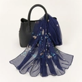 Elegant navy blue georgette scarf with floral print draped over a black handbag - 160x50cm / Navy Floral