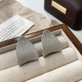 Macro shot of silver-toned triangle earrings with granular texture on velvet display - Inverted Triangle Grainy Stud Earrings / Silver