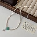 Detalle de un collar de perlas con colgante de trébol de cuatro hojas verde - Collar de Perlas de Piedra Natural Verde
