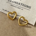 Close-up of matte champagne gold hollow heart stud earrings with brushed metal texture - Brushed Heart Style / Gold