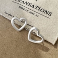 Macro shot of matte silver heart-shaped stud earrings with a brushed metallic texture - Brushed Heart Style / Silver