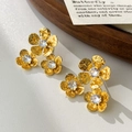 Dettaglio ravvicinato di orecchini a lobo floreali in oro con zirconi brillanti - Oro