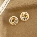 Macro view of gold butterfly zircon earrings with creamy resin ring on brown paper - White Butterfly Stud Earrings