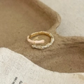 Makro-Detail des goldenen Bambusrings mit rosa Emaillierung und weißen Zirkonia-Steinen - Rosa