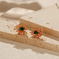 Luxury gold starburst earrings with green oval zircon on a beige marble surface - Gold Green Zircon Stud Earrings