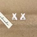 Detail of X-shaped stud earrings with pink enamel finish and shimmering zircon stones - Pink