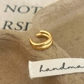 Detalle de earcuff dorado de doble capa sobre un fondo de papel con textura retro - Ear Cuff de Doble Capa / Dorado