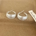 Minimalist silver multi-layered wrap hoop earrings on a textured paper background - C-Shape Stud Earrings (A-779) / Silver