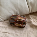 Ethnic embroidered mini makeup bag with zipper closure on textured linen background - Brick Red