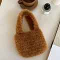 Detailed close-up of brown plush woven handbag featuring soft metallic fiber texture - Caramel color