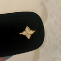 Macro view of a gold flower ring with zircon inlays on a black velvet box - Gold Zirconia Inlaid Ring