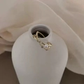 Detail van een goudkleurige kruisring met witte parel en schitterende zirkonia accenten - Verstelbaar Open / Goud/Kruis Zirkoon