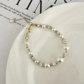 Dettaglio di un bracciale di perle regolabile con sfere Shamballa lucide e oro - Bracciale con Sfera Shamballa Bianca