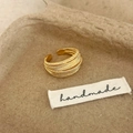 Detailed close-up of handmade gold multi-layer woven ring on rustic fiber background - Open Ring (C-17) / Gold