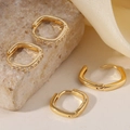 Set di orecchini a cerchio geometrici dorati con stili lucidi e zirconi su sfondo di pietra - Orecchini a Cerchio Quadrati Oro (A-16)