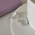 Dettaglio macro di orecchini a cerchio a C in argento intrecciato con design a fili stratificati - Argento