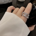 Macro shot of silver-tone hollow chain ring featuring cubic zirconia stones on hand - Silver